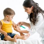 医師が子供にワクチンを接種しているところ