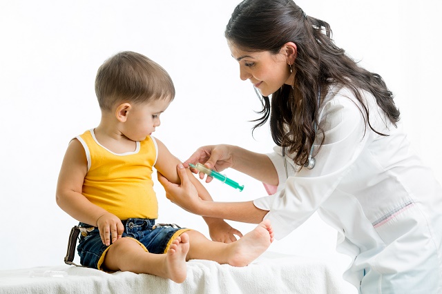 医師が子供にワクチンを接種しているところ