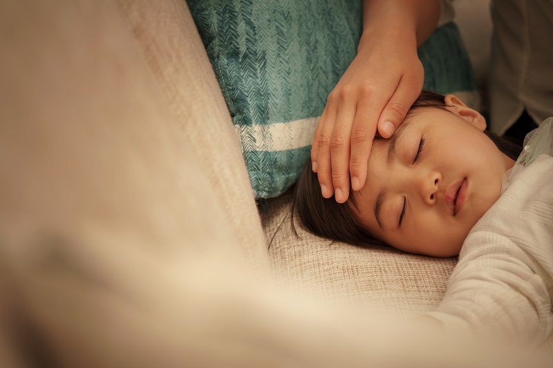 子供の熱を計るお母さん