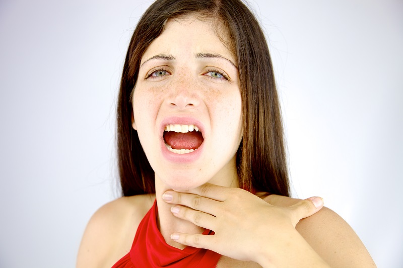 喉を抑える女性