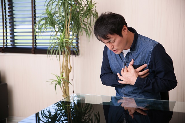 心臓をおさえる男性