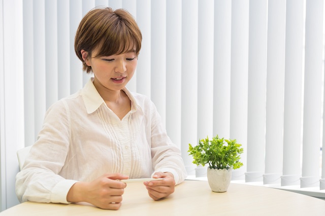 熱をはかる女性