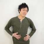 お腹に手を当てて苦い顔の男性