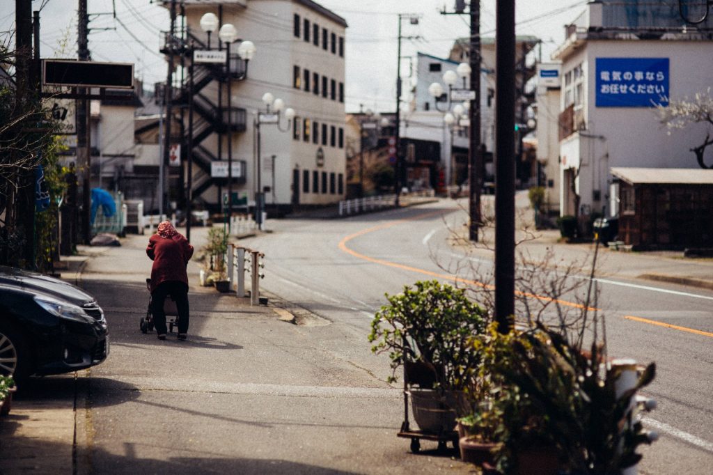 閑散とした道路と老人-写真