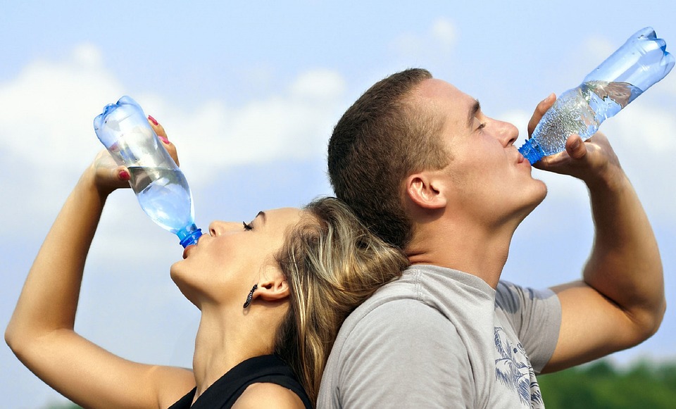 ペットボトルで水を飲む男女