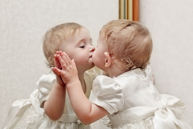 鏡にキスする赤ちゃん
