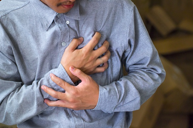 胸を押さえて苦しむ男性