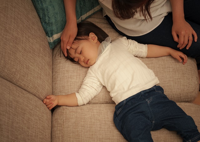 子供の熱を計るお母さん