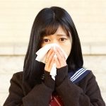 花粉症で鼻をかむ女子生徒