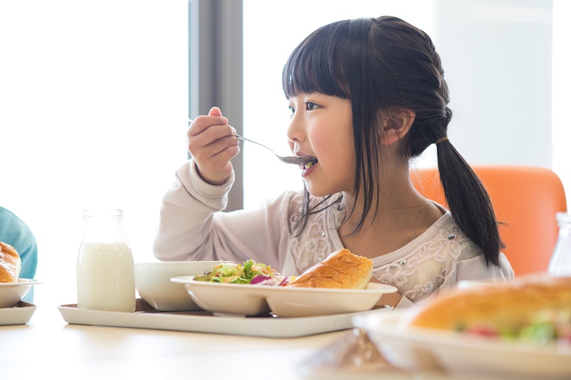 給食を食べる小学生