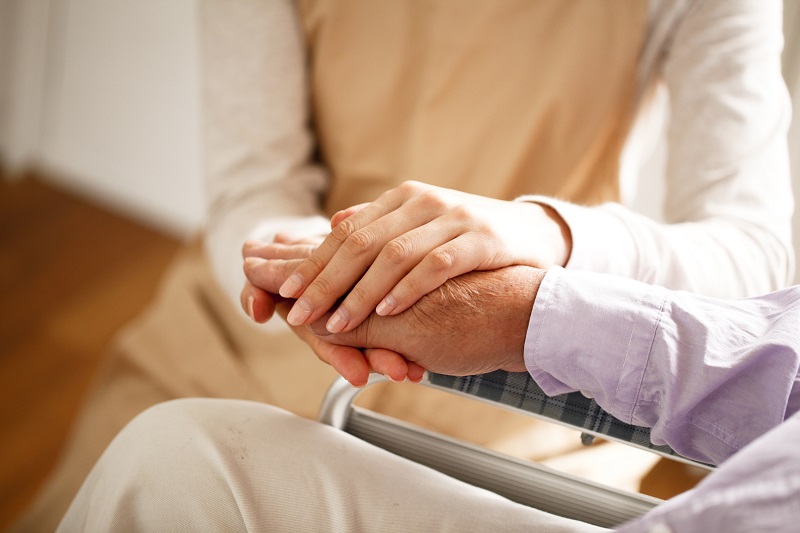 手を握り合う患者と介護者